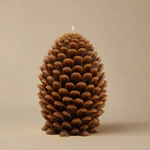 Pine cone-shaped candle on a white background