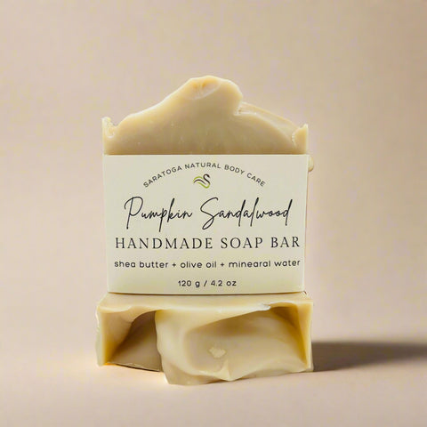 Handmade soap bar with sandalwood scent on a wooden stand with autumn leaves in the background