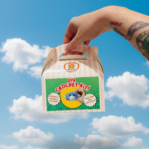 Hand holding a DIY crochet kit packaging