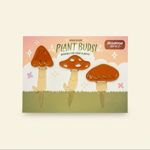 Set of three mushroom-shaped planters on a decorative card with 'Plant Buds!' branding on a wooden surface.