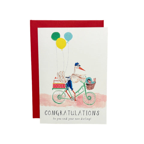 Congratulations card with stork and baby illustration on a wooden surface