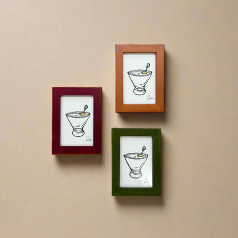 Three framed illustrations on a wooden wall.