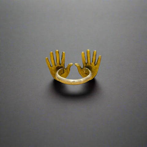 Brass ring with a unique design on a wooden surface