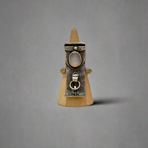 Sterling silver ring on a wooden surface with a blurred background
