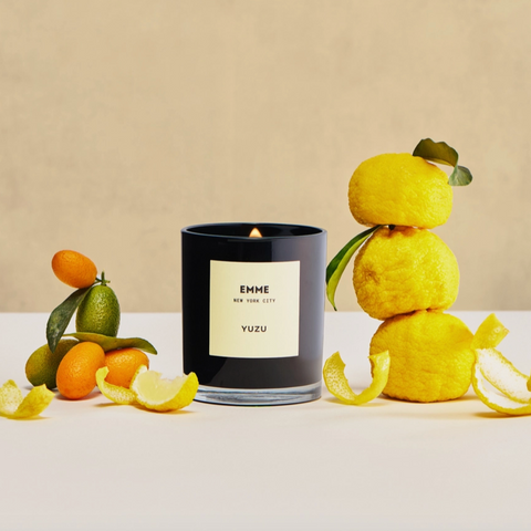 Yuzu candle with yuzu fruits on a beige background