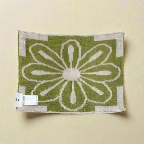 Green and beige patterned fabric with a floral design on a white background
