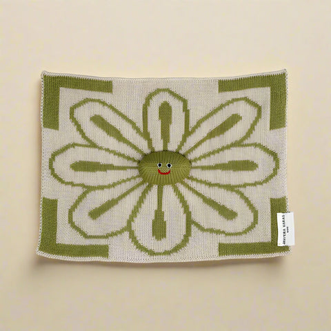Knitted square with a smiling flower design on a white background