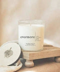 Candle labeled 'sweet comfort' on a wooden stand with soft lighting