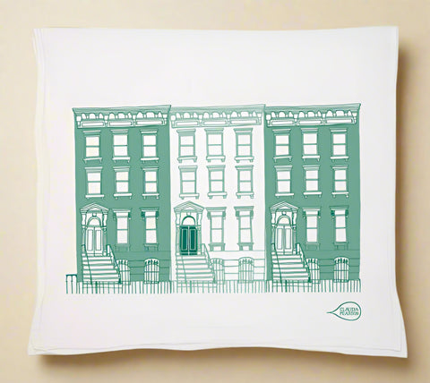 Tea towel with green building illustration on a white background