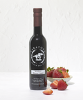 Bottle of Aratoga Olive Oil Co. Strawberry Balsamic Vinegar with strawberries on a white background