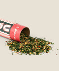 Spice container with spilled contents on a beige background