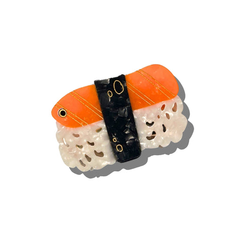 Sushi-shaped compact mirror with orange rice, black seaweed, and white fish on a white background