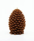 Pine cone-shaped candle on a white background