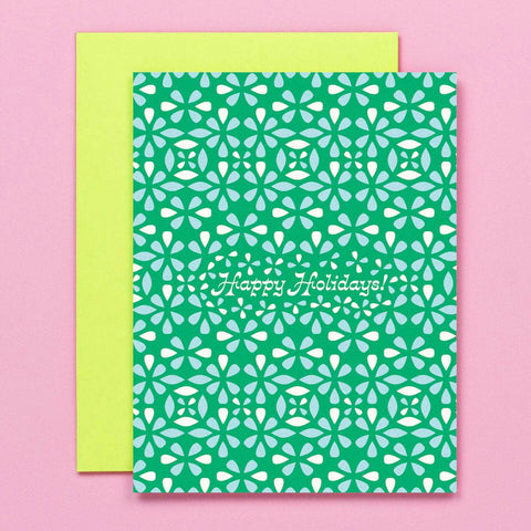 Green card with white floral pattern and 'Happy Holidays' text on a pink background