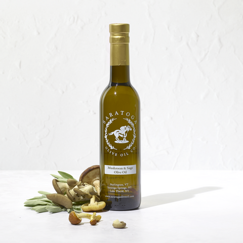 Bottle of Saratoga Olive Oil Co. olive oil with mushrooms and sage on a white background