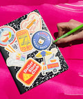 Notebook with colorful stickers on a bright pink background