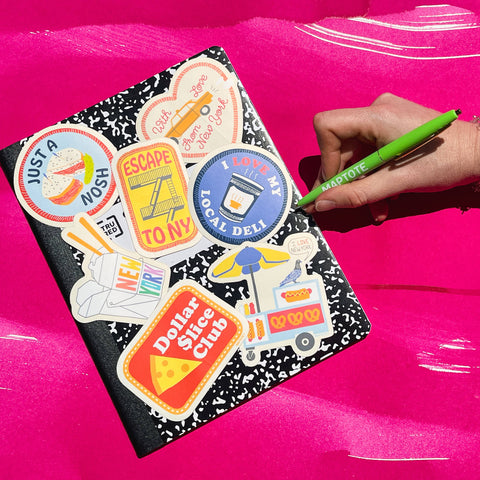 Notebook with colorful stickers on a bright pink background