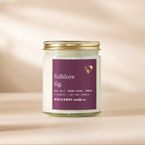 Candle jar labeled 'Folklore Fig' on a beige background