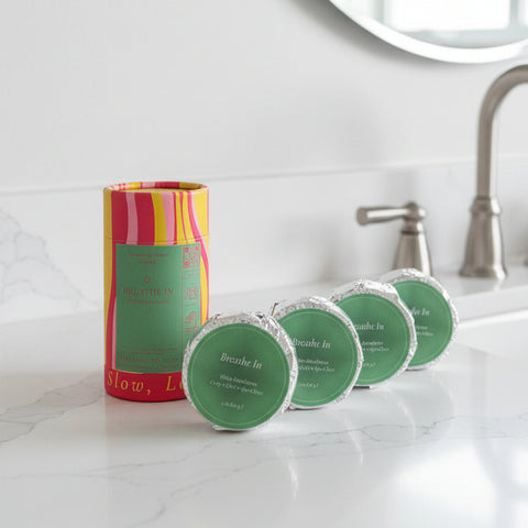 Set of green tins with a colorful cylindrical container on a white background