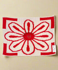 Red and white knitted blanket with a smiley face design on a white background