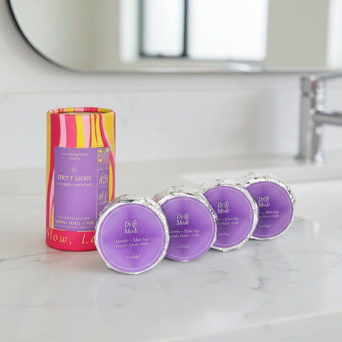 Set of purple containers with a striped cylindrical product on a white background