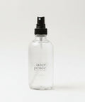 Clear spray bottle labeled 'inner peace' on a light surface with soft lighting.