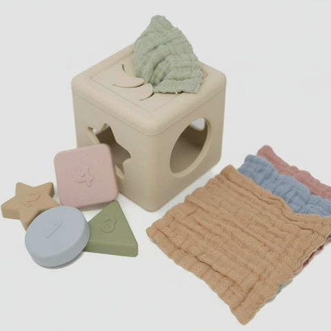 Colorful baby blocks and textured fabric on a light background