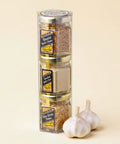 Spice set in a clear cylindrical container on a wooden surface