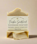 Handmade soap bar with sandalwood scent on a wooden stand with autumn leaves in the background