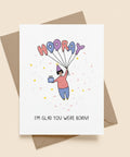 Greeting card with cartoon illustration and 'Hooray! I'm glad you were born!' text on a white background