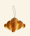 Decorative croissant candle on a white background
