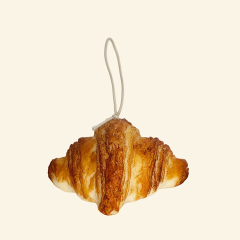 Decorative croissant candle on a white background