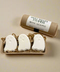 Ghost-shaped shower steamers with a cardboard tube labeled 'Ghost Shower Steamers' on a wooden surface.