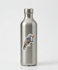 A die-cut sticker featuring a collage-style bird with newspaper print wings and a blue-and-white baguette-shaped accessory, shown on a plain light background.