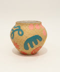 A handmade ceramic pot with a speckled beige surface, decorated with teal, pink, and orange abstract patterns.