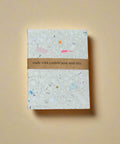 Notebook with confetti design on a cardboard background