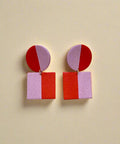 Pair of earrings with geometric design on a wooden surface