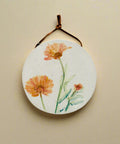Round floral wall hanging on a wooden surface