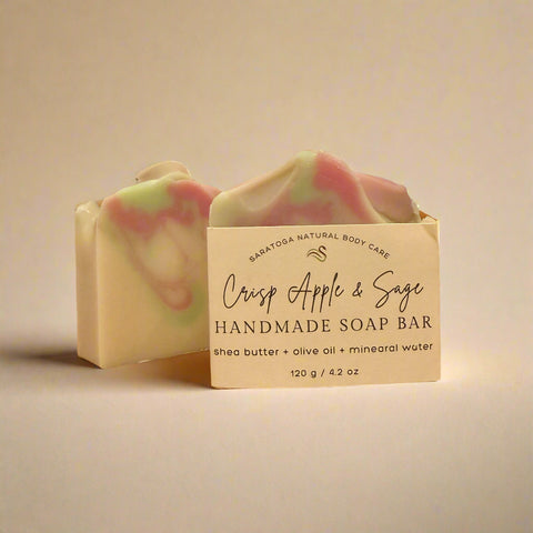 Handmade soap bar with 'Crisp Apple & Sage' scent on a wooden surface.