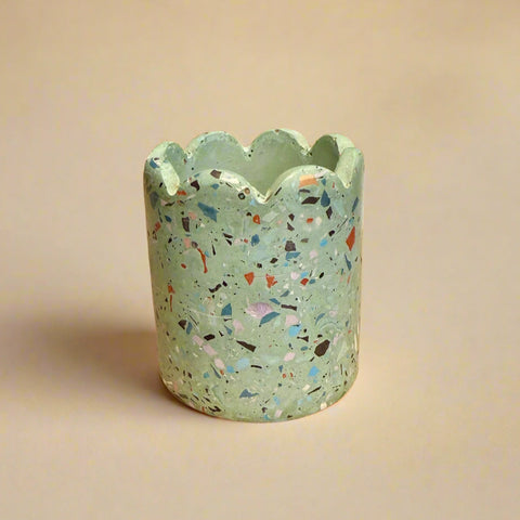 Decorative terrazzo-patterned pot on a cardboard box with a blurred background