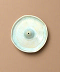 Round ceramic incense holder on a wooden surface