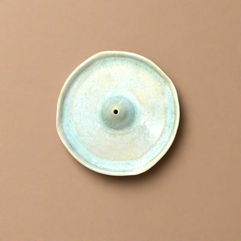 Round ceramic incense holder on a wooden surface