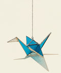 Decorative crane-shaped suncatcher on a chain.