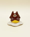 Small figurine of a brown bear on a fried egg