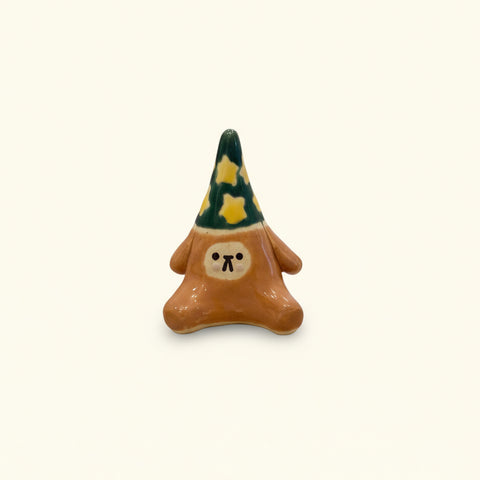 Small brown bear figurine with a green hat.