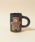 Ceramic mug with a bear design on a wooden surface