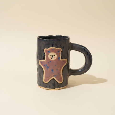 Ceramic mug with a bear design on a wooden surface