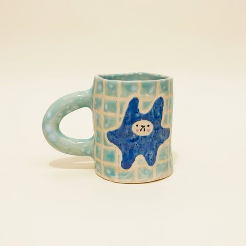 Ceramic mug with a blue star design on a wooden surface