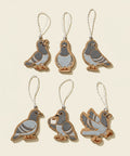 Six pigeon-shaped ornaments on a wooden surface