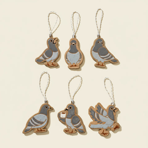 Six pigeon-shaped ornaments on a wooden surface